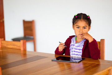 Naklejka premium Una niña campesina en el aula conectada en Tablet, educación rural, Niña bonita aprendiendo y dibujando con el profesor en línea en tablet digital clases,
