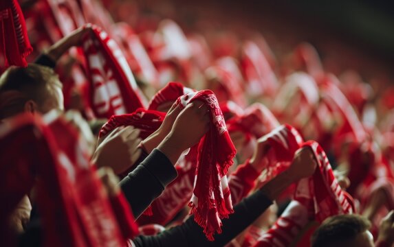 Close-up of fans' hands holding scarves and banners of their team