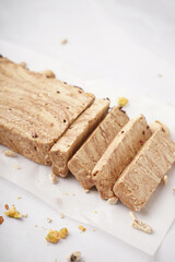 Pieces of tasty marble halva on light background