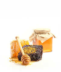 Different types of honeycombs, close-up. Types of honeycomb with bee pollen on surface and a jar of farmers honey isolated on white background. Honeycombs with wild forest honey and honey spoon.