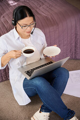 Obraz premium Focused female freelancer is using her laptop indoors