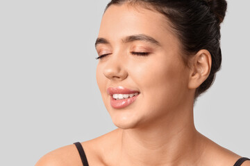 Obraz premium Young woman with beautiful lips on light background, closeup