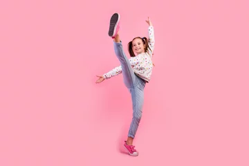 Foto op Plexiglas Dansschool Full length photo of graceful girl wear stylish sweatshirt jeans raising leg up dancing look empty space isolated on pink color background