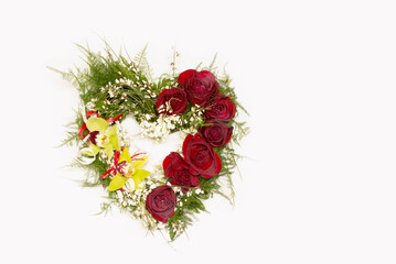 Festive Floristry flower arrangement in heart shape from red roses and orchids, isolated on white. Funeral floristry, composition at the cemetery