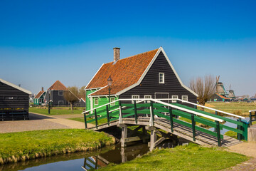 Fototapeta na wymiar Little wooden bridge over a canal in Zaanse Schans, Netherlands