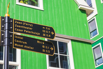 Tourist sign in front of a traditional green house in Zaandam, Netherlands