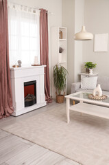 Interior of living room with modern fireplace, different home decorations and sofa