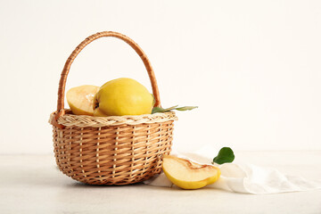 Wicker basket with sweet ripe quinces on white background