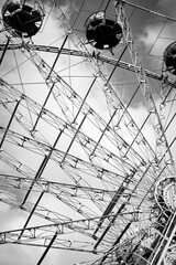 Ferris wheel in an amusement park against a blue sky black and white photo