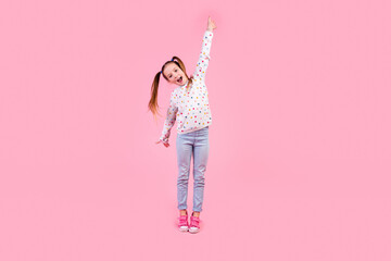 Full length photo of good mood small girl wear stylish sweatshirt jeans announcing big season sale isolated on pink color background