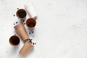 Paper cups of hot coffee and beans on white background
