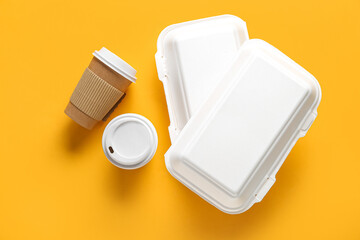 Takeaway paper cups and containers on yellow background