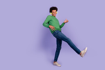 Photo of funky cool guy wear green pullover headphones playing music guitar empty space isolated purple color background