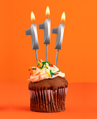 Birthday cupcake with number 111 candle - Orange color background