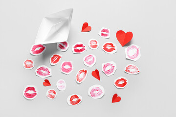 Composition with paper boat, hearts and lipstick kiss marks on grey background. Valentine's Day celebration