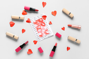 Obraz premium Composition with greeting card, lipsticks and paper hearts on grey background. Valentine's Day celebration