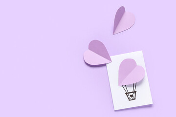 Beautiful greeting card with paper hearts on lilac background. Valentine's Day celebration