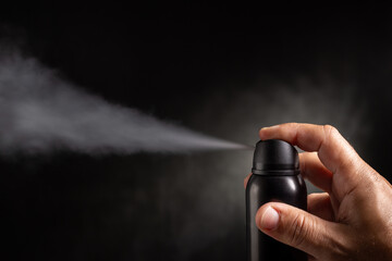 Deodorant spray on dark background.