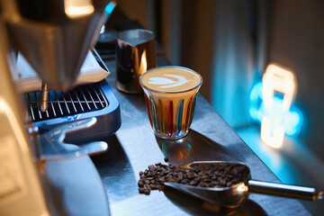 Coffee shop counter with coffee machine scoop with beans and cup of cappuccino