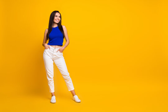 Full length photo of cute adorable woman wear blue top looking empty space isolated yellow color background
