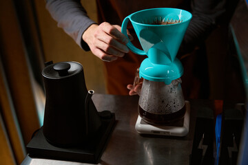 Coffee maker preparing black coffee in filter in coffee shop
