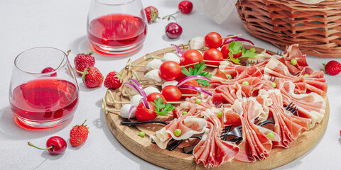 Picnic food concept. Basket with wine and baguette, set of snacks on skewers. Meat, cheese