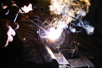 Welding metal with electrodes, sparks and smoke