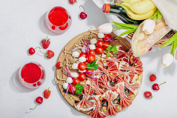 Picnic food concept. Basket with wine and baguette, set of snacks on skewers. Meat, cheese