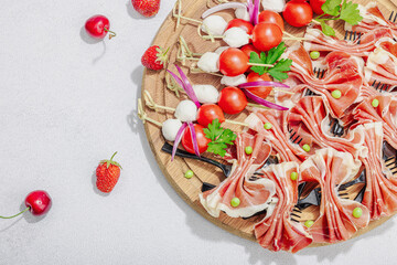Picnic food concept. Basket with wine and baguette, set of snacks on skewers. Meat, cheese