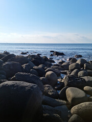 This is a Jeju beach with blue skies and basalt rocks.