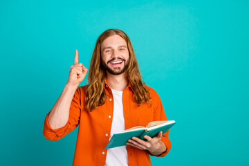 Photo of clever guy with wavy hairdo wear stylish outfit holding book raising finger up have idea...