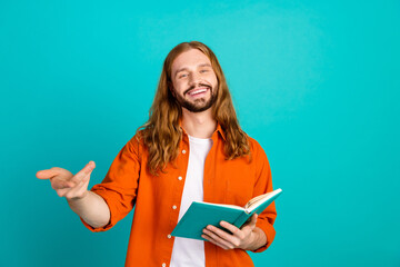 Photo of positive cheerful guy with wavy hair wear stylish outfit presenting you his new book...