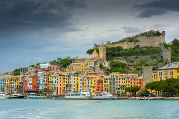 Beautiful view of the colorful town of Portovenere with the castle and cloudy sky, view from the sea, Liguria,  Italy