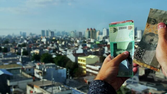 A foreign man counts Indonesian money.