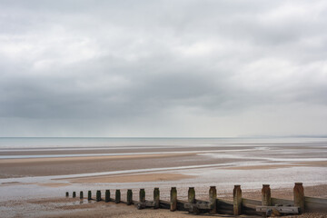 Groynes on Camber Sands on an autumn day, view of the beach and the English Channel, East Sussex, England