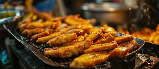 Popular street food in Southeast Asia, especially in Indonesia, Malaysia, and Singapore, is fried banana, known as pisang goreng. - obrazy, fototapety, plakaty