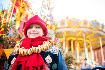 smiling boy at the traditional Russian festival dedicated to the meeting of spring, the week of pancakes, Shrovetide. the child stands at the decorations for the Maslenitsa holiday