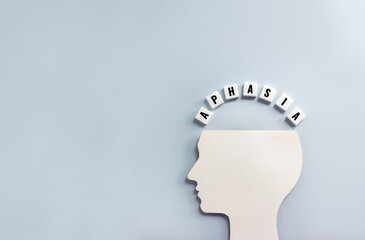 Silhouette of human head and word Aphasia made from plastic blocks with letters. Disease concept,...