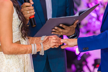 Indian couple's exchanging wedding rings hands close up