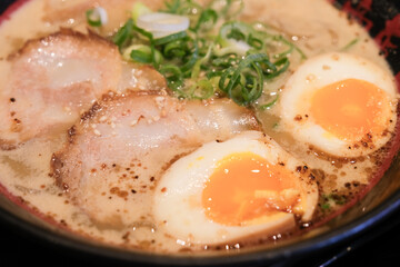 Closeup of Japanese noodle with pork and eggs in the soup.
