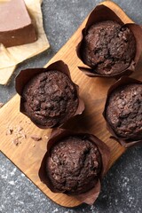 Tasty chocolate muffins on grey table, top view