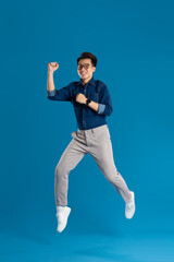Fototapeta na wymiar Portrait of young Asian business man posing on blue background