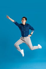 Obraz premium Portrait of young Asian business man posing on blue background