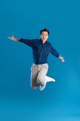 Obraz premium Portrait of young Asian business man posing on blue background