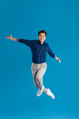 Obraz premium Portrait of young Asian business man posing on blue background