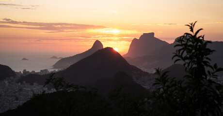 Unique sunset view from the top of a mountain in Rio de Janeiro, with the ocean on the background.