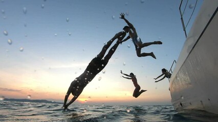 Group of young friends jumping to the beach, having a party in yacht. 