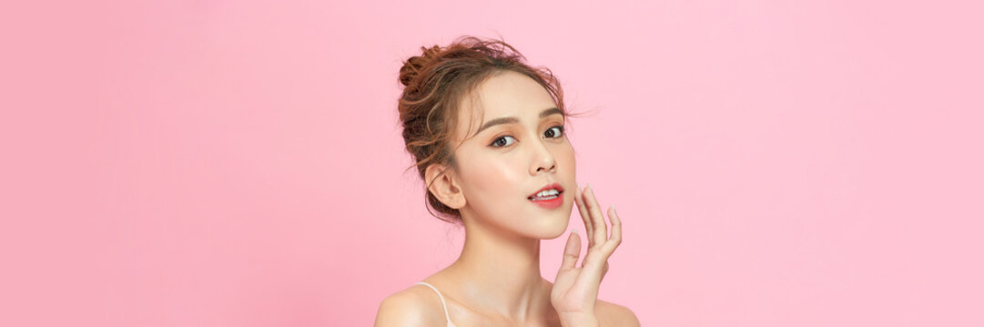 Beauty head shot of young asian woman on pink pastel background