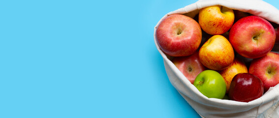 Variety of fresh apples on blue background.