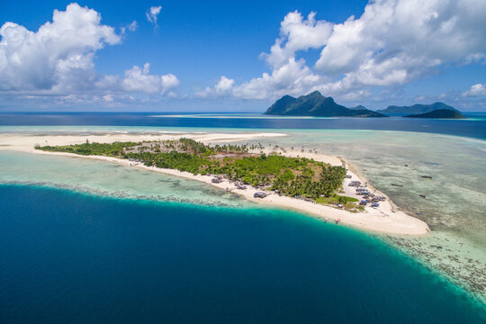 Aerial view of Maiga island panorama, beautiful blue lagoon and coral reef.